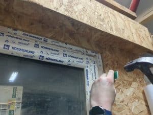 Plastic packers being installed round window